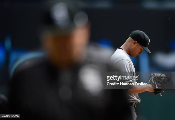 Jose Quintana of the Chicago White Sox looks on as pitching coach Don Cooper returns to the dugout after a visit to the mound during the first inning...