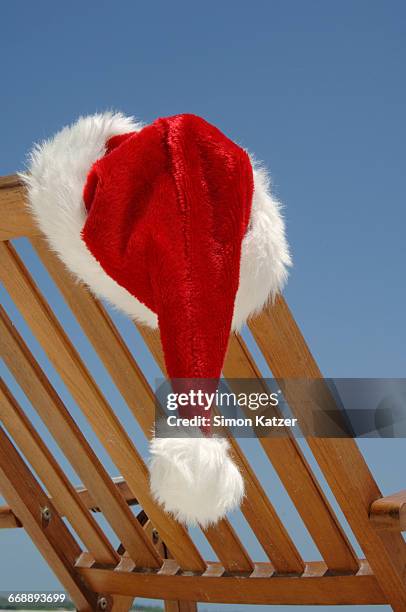 santa claus cap hanging at a deck chair - cap hat stockfoto's en -beelden