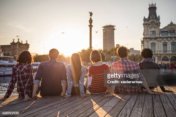 amigos sentados en la fila en el paseo marítimo - tour of catalonia fotografías e imágenes de stock