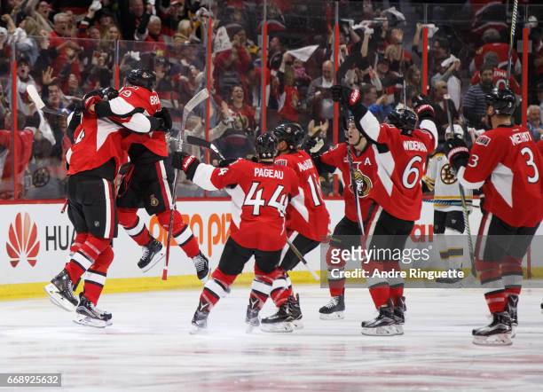 Dion Phaneuf of the Ottawa Senators celebrates his game-winning overtime goal against the Boston Bruins with teammates including Derick Brassard,...