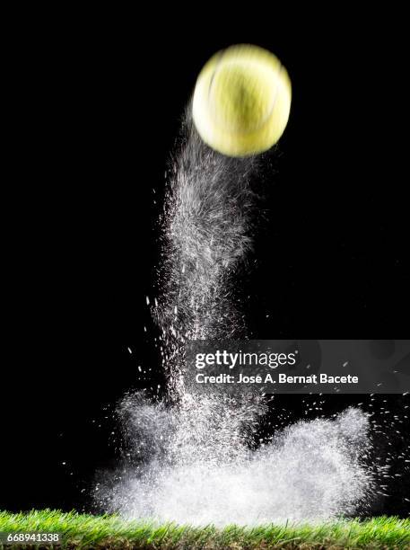 rebound of a ball of tennis for the impact on a surface of lawn, of an field of game, with ascending powder - partícula stock-fotos und bilder