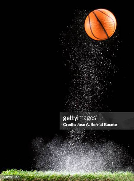 rebound of a ball of basketball for the impact on a surface of lawn, of an field of game, with ascending powder - fondo negro stock pictures, royalty-free photos & images