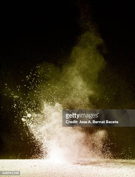 explosion of a cloud of powder of particles of yellow color on a black background - conceptos stock pictures, royalty-free photos & images
