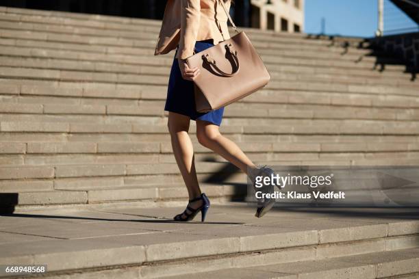 businesswoman walking on staircase with bag - tacchi alti foto e immagini stock
