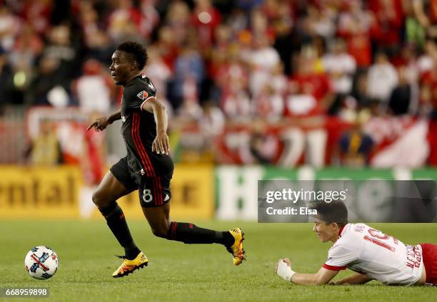 Lloyd Sam of D.C. United takes the ball as Alex Muyl of New York Red Bulls falls at Red Bull Arena on April 15, 2017 in Harrison, New Jersey.