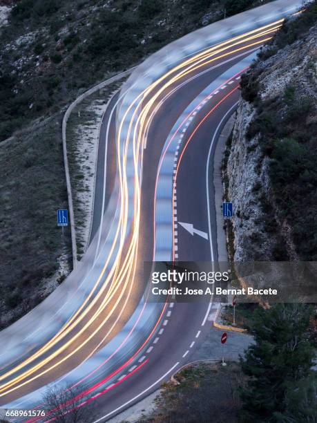 lights of vehicles circulating along a road of mountain with curves closed in the shape of s,  in the night - vía principal stockfoto's en -beelden