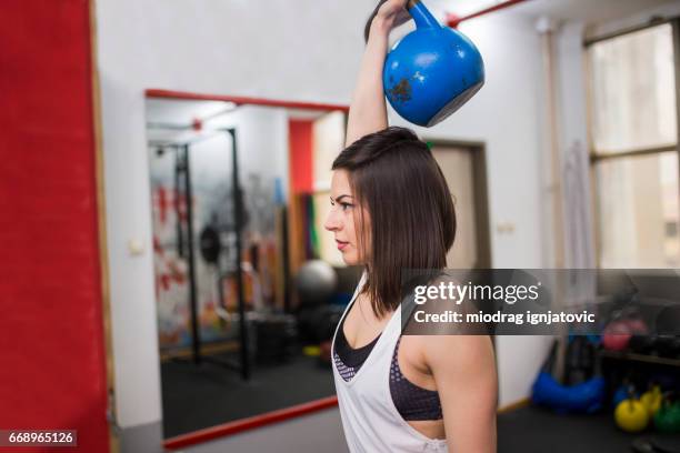 jonge vrouw gewichtheffen in de sportschool - build series presents the cast of snatch stockfoto's en -beelden