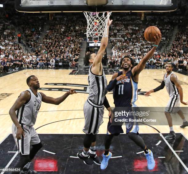Mike Conley of the Memphis Grizzlies drives under Danny Green of the San Antonio Spurs in Game One of the Western Conference Quarterfinals during the...