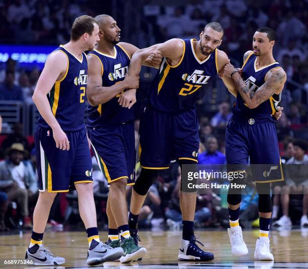Rudy Gobert of the Utah Jazz is helped off the court by Joe Ingles, Boris Diaw and George Hill after an injury during the first half against the LA...