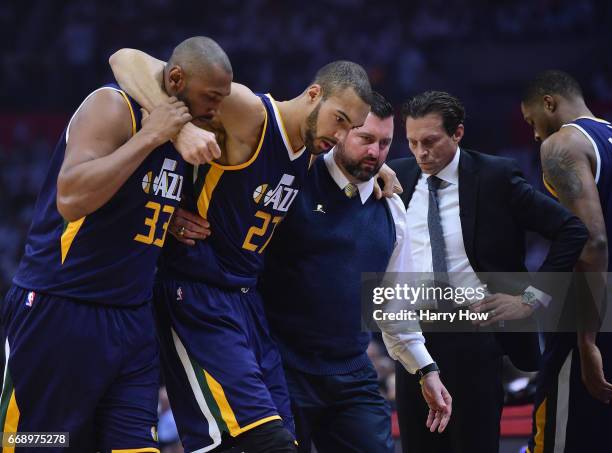 Rudy Gobert of the Utah Jazz is helped off the court past head coach Quin Snyder, by Boris Diaw and medical staff during the first half against the...