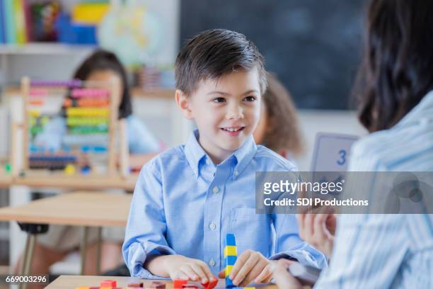 teacher shows flash cards to young male student - flash card stock pictures, royalty-free photos & images