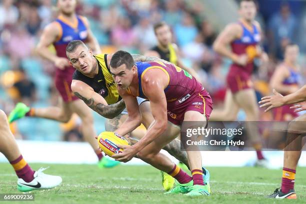 Tom Rockliff of the Lions is tackled by Dustin Martin of the Tigers during the round four AFL match between the Brisbane Lions and the Richmond...