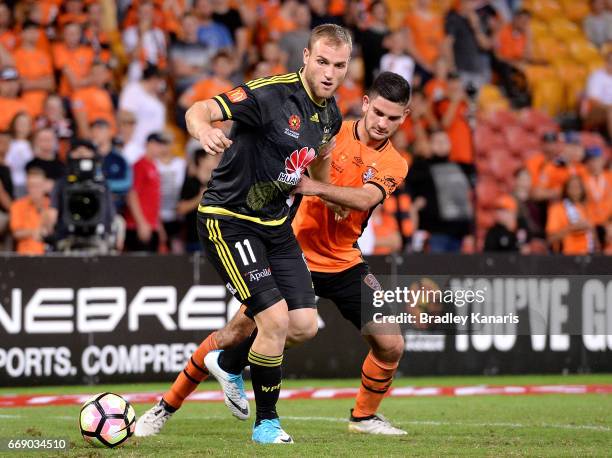 Hamish Watson of the Phoenix is pressured by the defence of Cameron Crestani of the Roar during the round 27 A-League match between the Brisbane Roar...