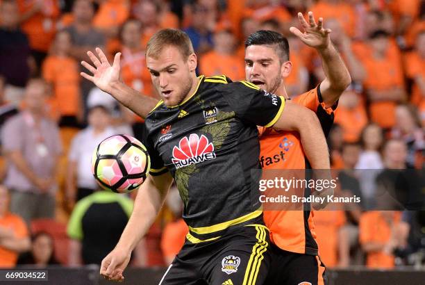 Hamish Watson of the Phoenix is pressured by the defence of Cameron Crestani of the Roar during the round 27 A-League match between the Brisbane Roar...