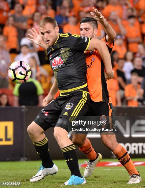 Hamish Watson of the Phoenix is pressured by the defence of Cameron Crestani of the Roar during the round 27 A-League match between the Brisbane Roar...