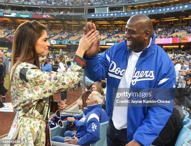 Antonella Barba gets a high five from Magic Johnson after singing the National Anthem before the game between the Los Angeles Dodgers and the Arizona...