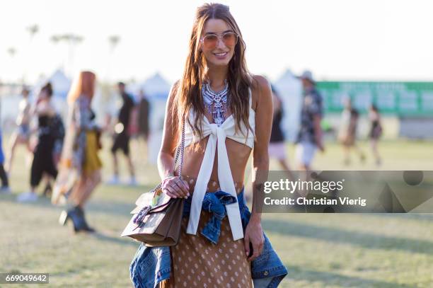 Jemma wearing Gucci bag, skirt, cropped top, denim jacket, sunglasses during day 2 of the 2017 Coachella Valley Music & Arts Festival Weekend 1 on...