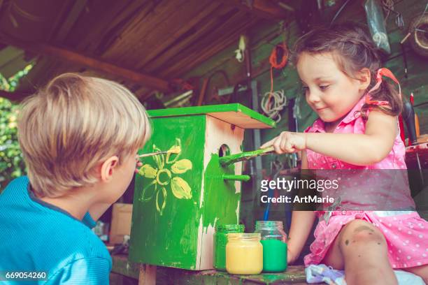 enfants font et peignent birdhouse - atelier enfant photos et images de collection