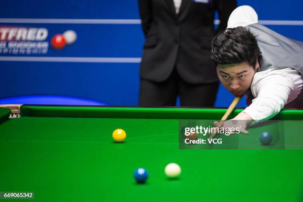 Yan Bingtao of China plays a shot during his first round match against Shaun Murphy of England on day two of Betfred World Championship 2017 at...