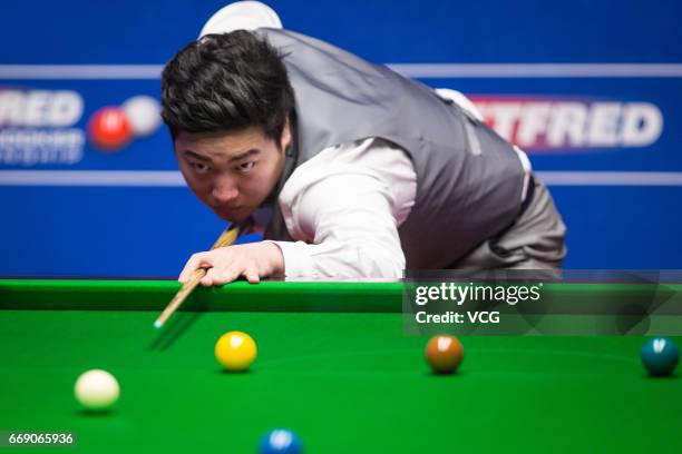 Yan Bingtao of China plays a shot during his first round match against Shaun Murphy of England on day two of Betfred World Championship 2017 at...