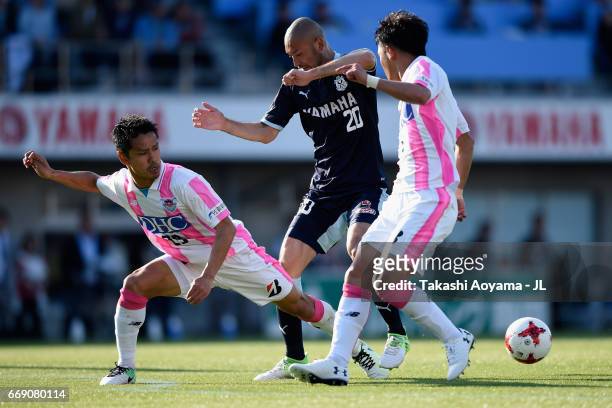 Kengo Kawamata of Jubilo Iwata competes for the ball against Hiroyuki Taniguchi and Masato Fujita of Sagan Tosu during the J.League J1 match between...