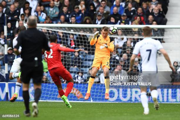 Liverpool's Belgian goalkeeper Simon Mignolet defends the goal as West Bromwich Albion's English-born Scottish midfielder James Morrison and...