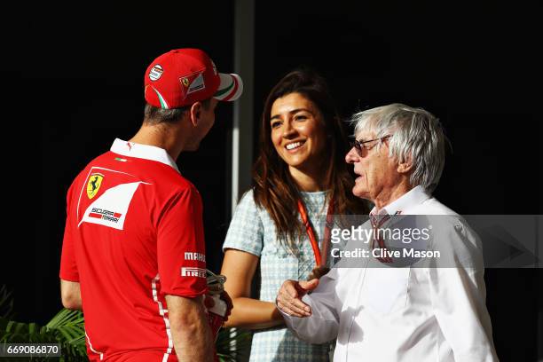 Sebastian Vettel of Germany and Ferrari talks with Bernie Ecclestone, Chairman Emeritus of the Formula One Group and his wife Fabiana before the...