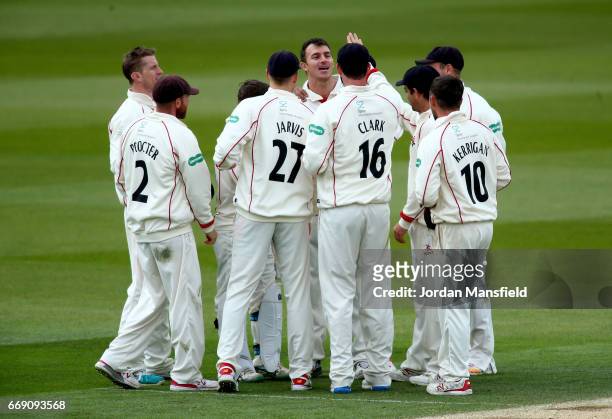 Ryan McLaren of Lancashire celebrates with his teammates after getting the wicket of Sam Curran of Surrey during day three of the Specsavers County...