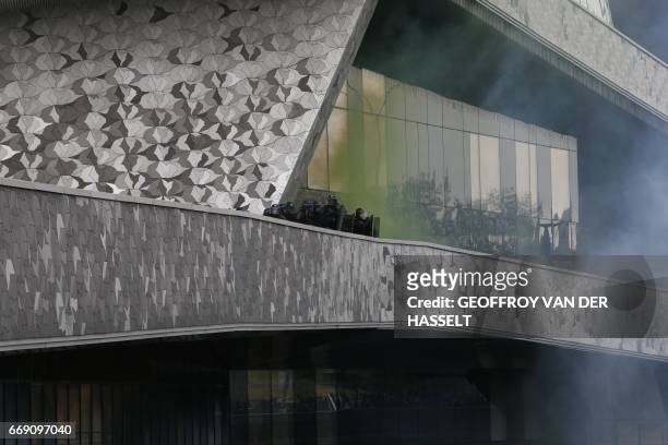 Anti-riot Gendarmes take position on a walkway of the Paris Philharmonic building, as clashes erupt during an anti-facist demonstration on April 16,...
