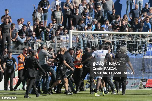 Bastia's supporters invade the pitch and shoot at Lyon players during warm up prior to the French L1 Football match between Bastia and Lyon on April...