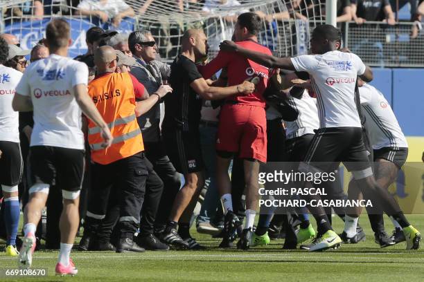 Stewards and Lyon staff members try to stop Bastia's supporters who invade the pitch to fight with Lyon players during warm up prior to the French L1...