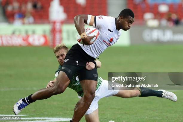 Dylan Sage of South Africa tackles Osea Kolinisau of Fiji during the 5th Place Semi Final 2017 Singapore Sevens match between Fiji and South Africa...