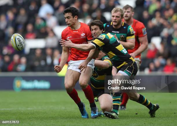 Alex Lozowski of Saracens off loads the ball as Lee Dickson tackles during the Aviva Premiership match between Northampton Saints and Saracens at...