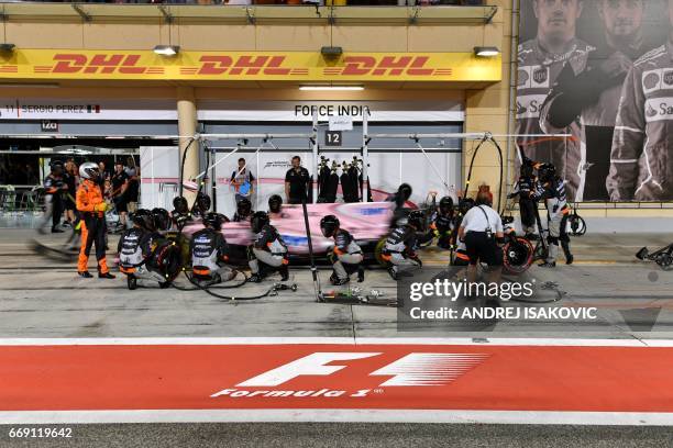 Pit crew and mechanics surround Force India's Mexican driver Sergio Perez in the pit lane during the Bahrain Formula One Grand Prix at the Sakhir...