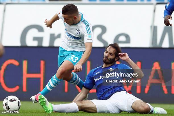 Donis Avdijaj of Schalke is challenged by Hamit Altintop of Darmstadt during the Bundesliga match between SV Darmstadt 98 and FC Schalke 04 at...