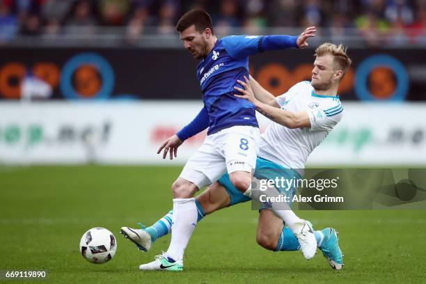 Jerome Gondorf of Darmstadt is challenged by Johannes Geis of Schalke during the Bundesliga match between SV Darmstadt 98 and FC Schalke 04 at...