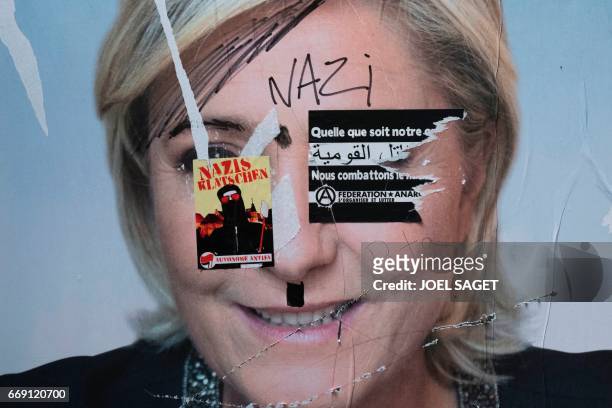 This picture taken in Paris on April 15 shows an electoral poster of French presidential election candidate for the far-right Front National party,...