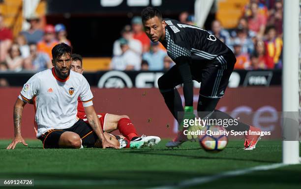Ezequiel Garay and Diego Alves of Valencia competes for the ball with Stevan Jovetic of Sevilla during the La Liga match between Valencia CF and...