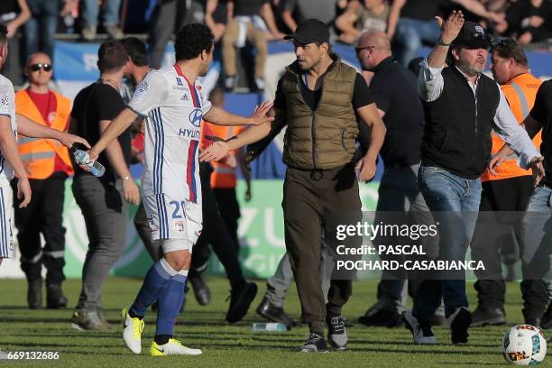 Bastia's official argues with Lyon's Brazilian defender Rafael da Silva during scuffles at half-time between some of Lyon's players and Bastia's...