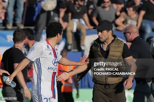 Bastia's official argues with Lyon's Brazilian defender Rafael da Silva during scuffles at half-time between some of Lyon's players and Bastia's...