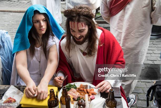 Luigi Pertrilli eats a Sunday roast outside the George pub next to a woman dressed like the Virgin Mary during the Christathon X pub crawl on April...