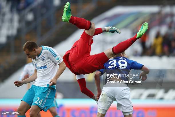 Goalkeeper Ralf Faehrmann of Schalke falls over team mate Holger Badstuber and Sven Schipplock of Darmstadt during the Bundesliga match between SV...