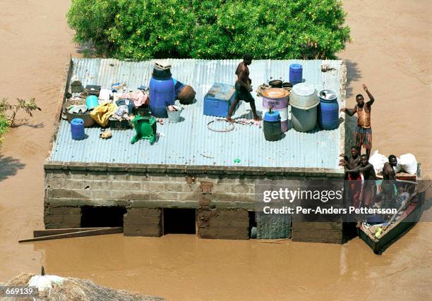 Villagers loot a house in a flooded area March 3, 2000 along the Limpopo river close to Chibuto, Mozambique. The country was hit by severe flooding...