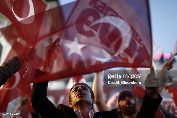 Residents wave 'Yes' and Turkish national flags outside of the AKP party headquarters as they react to the outcome of the referendum in Istanbul,...