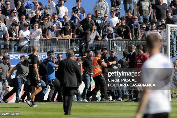 Bastia's supporters invade the pitch to try to fight with Lyon's Portuguese goalkeeper Anthony Lopes and players during their warm up prior to the...