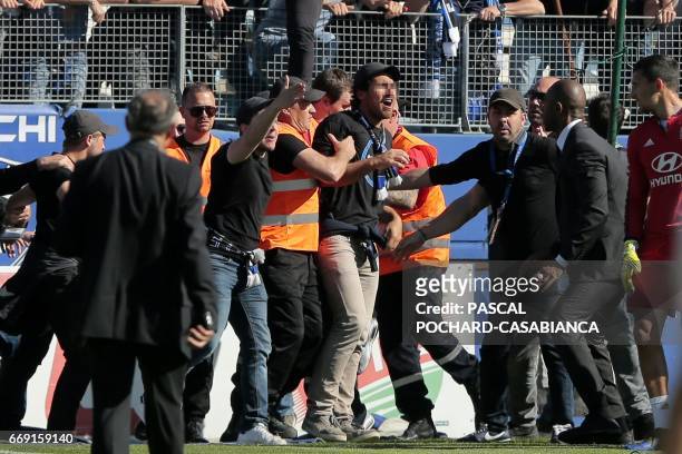 Bastia's supporters invade the pitch to try to fight with Lyon's Portuguese goalkeeper Anthony Lopes and players during their warm up prior to the...