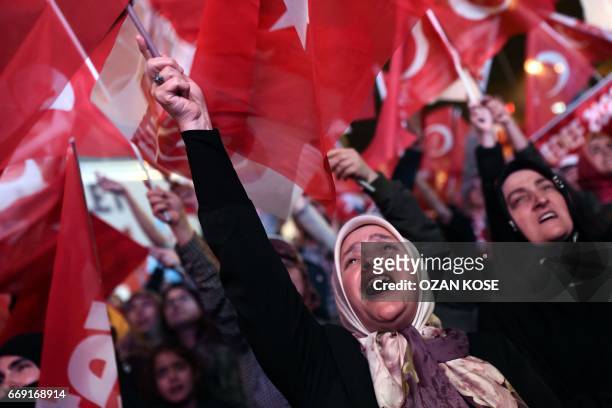 Woman supporting Turkish president waves a Turkish national flag as she celebrates during a rally near the headquarters of the conservative Justice...