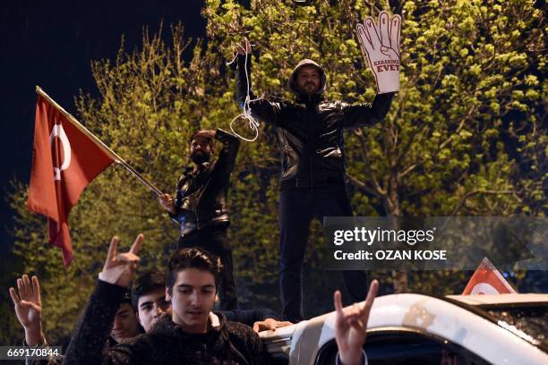 Supporters of the "yes" make the nationalist "grey wolves" sign and flash four fingers sign called "the rabia sign" as they celebrate on April 16,...