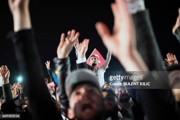 Supporters flash a four finger sign called "the rabia sign" as they celebrate and greet Turkish president during his speech at the conservative...