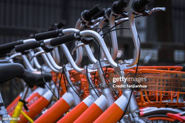 public rental bicycles in a line - bicycle parking station stock pictures, royalty-free photos & images